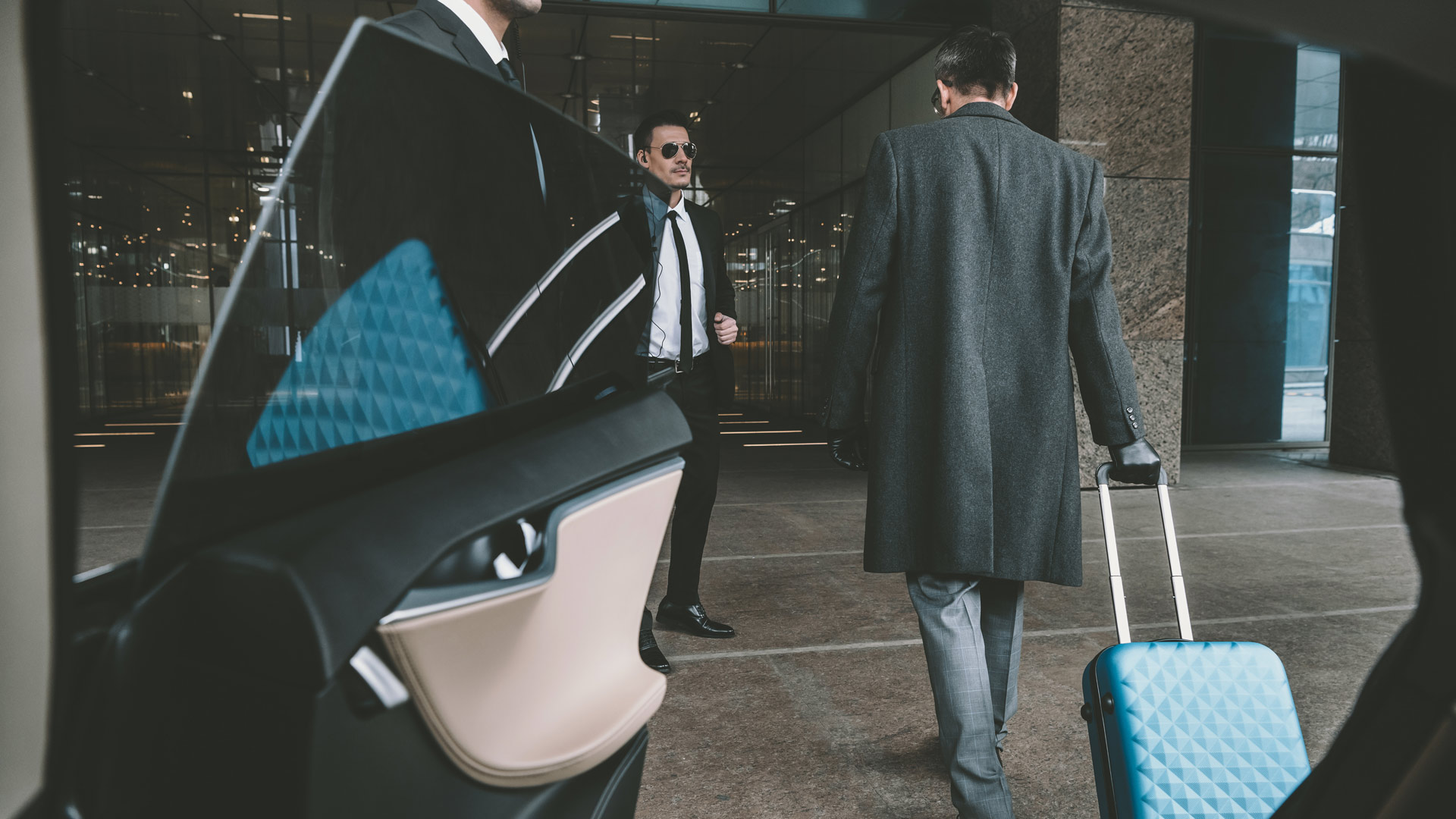 Businessman going with blue bag on wheels to airport